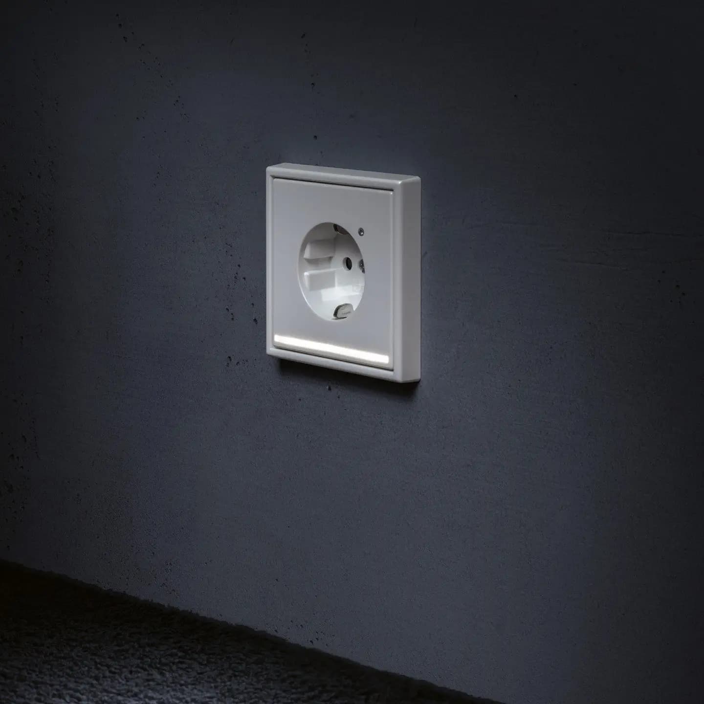 Steckdose an dunkler Wand